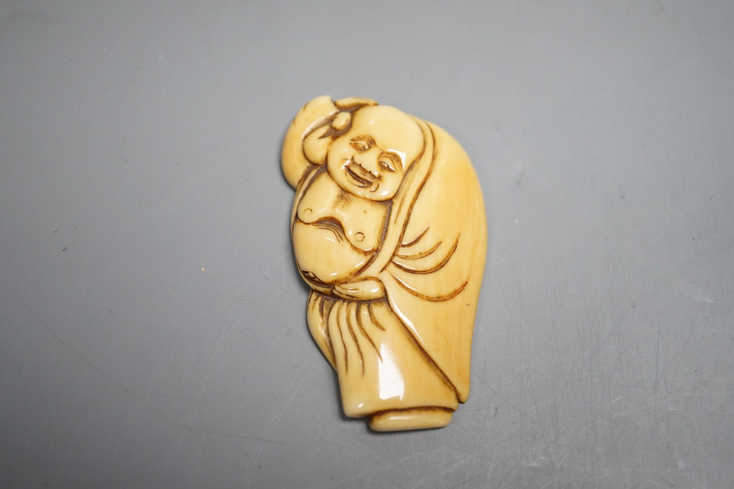 A Japanese Edo period ivory netsuke of Hotei and a Meiji period ivory netsuke of Daikoku and Ebisu, largest 6.5 cms high.